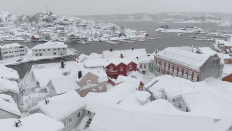 Kragero,-Telemark-County,-Norway---A-Charming-Town-Draped-in-Snow-on-a-Wintry-Day---Aerial-Pullback-Shot