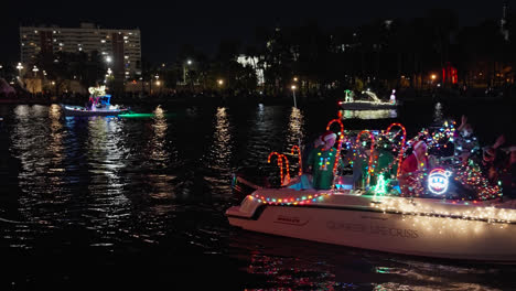 Gente-Celebrando-En-Un-Barco-Flotante-En-El-Desfile-De-Barcos-De-Navidad-En-Tampa,-Florida,-Toma-Nocturna