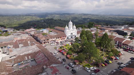 Aerial-View-Of-Filandia,-Quindío-Town-Square-With-Rolling-Green-Hills-In-Background