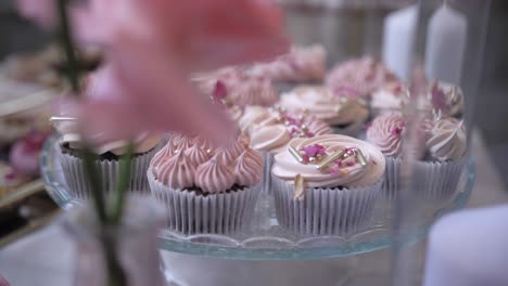 Leckere-Cupcakes-Mit-Köstlichem-Zuckerguss-Auf-Dem-Tisch,-Geringe-Schärfentiefe,-Dolly,-Filmische-Aufnahme