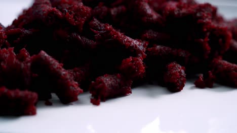 Close-up-of-slow-rotating-beet-pulp-on-a-plate-to-make-a-beet-pulp-chocolate-muffin