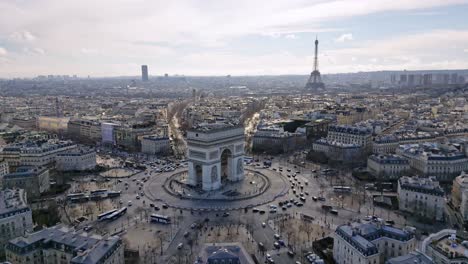 Triumphal-arch-or-Arc-de-Triomphe-with-Tour-Eiffel-and-Montparnasse-tower-in-background,-Paris-cityscape,-France