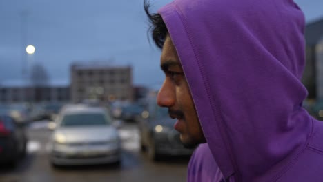 Close-up-of-young-Sri-Lankan-man-with-purple-hoodie-looking-around-at-park-space