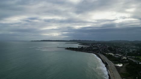 Toma-Aérea-De-Un-Dron-De-Una-Pintoresca-Ciudad-Costera-Bajo-Un-Espectacular-Cielo-Nublado-Durante-El-Anochecer