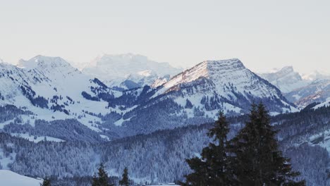 Luftaufnahme-Im-Morgengrauen,-Die-Die-Silhouette-Der-Schneebedeckten-Berge-Zeigt
