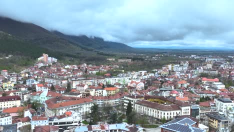 Toma-De-Drone-De-Un-Pequeño-Pueblo-Junto-A-Una-Montaña.