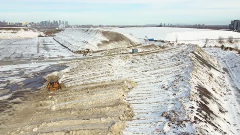 Ein-Bulldozer-Verteilt-Schmelzendes-Eis,-Damit-Es-Besser-Auftaut-Und-Wasseransammlungen-Verhindert-Werden