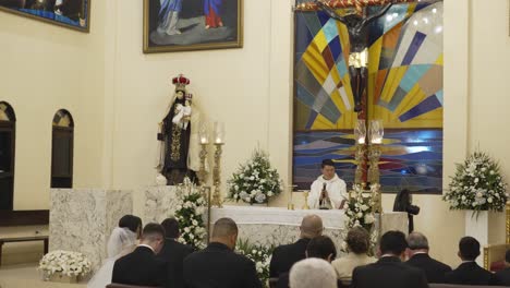 Hochzeitszeremonie-In-Der-Katholischen-Kirche,-Junges-Lateinamerikanisches-Paar-Steht-Am-Altar-Vor-Dem-Priester