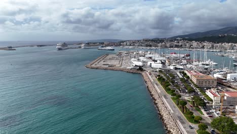 Palma-de-mallorca-marina-with-boats-and-coastline,-cloudy-sky,-aerial-view