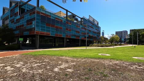 Modern-exterior-design-of-college-building-covered-in-solar-panels,-handheld-shot