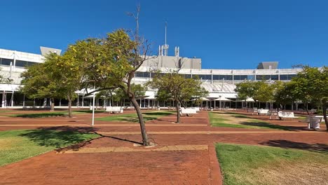 Moving-in-through-landscaped-grounds-of-college-building-on-clear-sunny-day