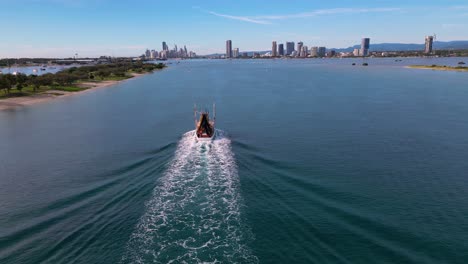 Aerial-views-over-the-Broadwater-as-a-fishing-trawler-comes-into-dock-on-the-Gold-Coast,-Australia