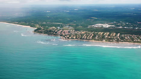 Aerial-view-of-Praia-do-Forte-beach,-the-city-around-and-the-vegetations-on-a-cloudy-day,-Praia-do-Forte,-Bahia,-Brazil