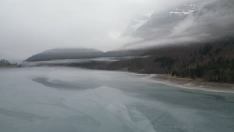 Klöntalersee-Glarus-Schweiz-Nebelschichten-über-Dem-See,-Der-Noch-Immer-Die-Spiegelung-Der-Berge-Zeigt