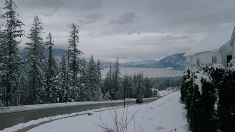 Schwarzer-LKW-Fährt-Auf-Einer-Verschneiten-Kurvigen-Straße-In-Salmon-Arm,-British-Columbia,-Kanada