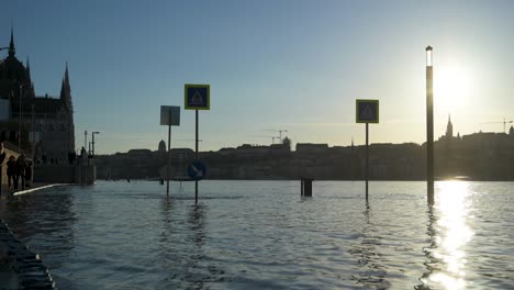 Flooded-crosswalk-at-the-House-of-Parliament-in-Budapest-with-the-Royal-Castle-of-Buda-in-the-background-during-the-flood-of-Danube-River,-Hungary---December-28,-2023