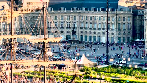 Gente-Reunida-En-La-Plaza-Place-De-La-Bourse-Durante-La-Feria-Del-Vino-Con-Un-Velero,-Tiro-Aéreo-A-La-Derecha