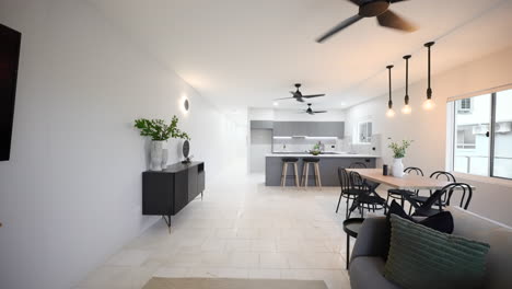 Sleek-Elegant-Modern-Luxurious-Grey-Apartment-Interior-Loungeroom-Living-Room-and-Kitchen-With-Ceiling-Fan-and-Over-Table-Lighting