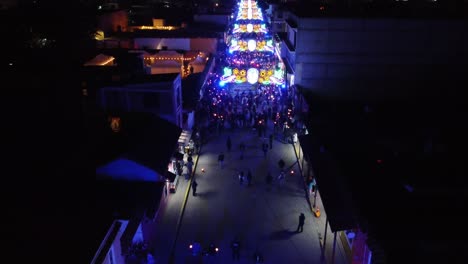 Multitud-De-Peatones-Caminando-Sobre-Iluminación-Y-Camino-Decorado-Por-La-Noche