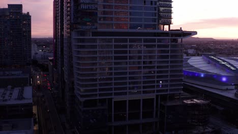 Aerial-rising-push-in-shot-of-the-abandoned-Oceanwide-Plaza-graffiti-skyscrapers-in-downtown-Los-Angeles,-California-at-sunset