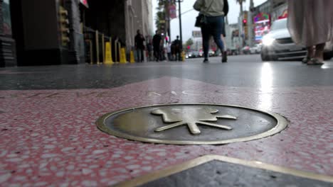 Steve-McQueen-walk-of-fame-star-in-Hollywood,-California-with-people-walking-by-and-stable-video