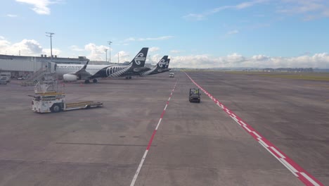 Airplanes-lined-up-at-gate-with-various-airport-ground-crew