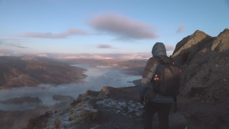 shot-of-a-hiker-walking-towards-the-edge-overlooking-Loch-Katrine-from-Ben-A'an