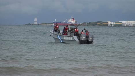 Küstenwache-Boot-Vor-Der-Küste-Des-Atlantischen-Meeres-In-Honduras-Mit-Dem-Frachtterminal-Von-Puerto-Cortés-Im-Hintergrund