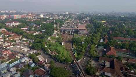 The-face-of-the-largest-railway-station-in-Malang,-East-Java,-is-juxtaposed-against-the-overcrowded-area,-adjacent-to-an-industrial-complex