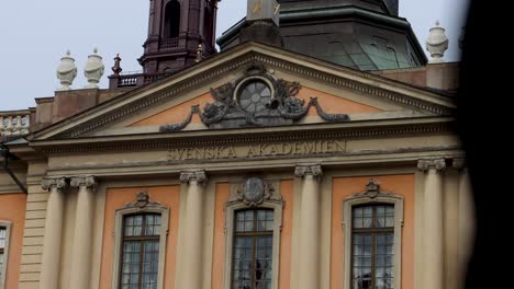 Exterior-of-Swedish-Academy-building-in-Stockholm,-person-walks-by