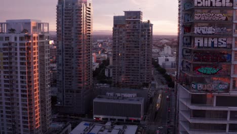 Toma-Aérea-Panorámica-En-Ayunas-De-Las-Torres-De-Graffiti-De-Oceanwide-Plaza-Al-Atardecer-En-El-Centro-De-Los-Ángeles,-California