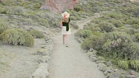 Woman-walking-along-the-pathway-while-carrying-her-child-at-the-Teide-National-Park-with,-static