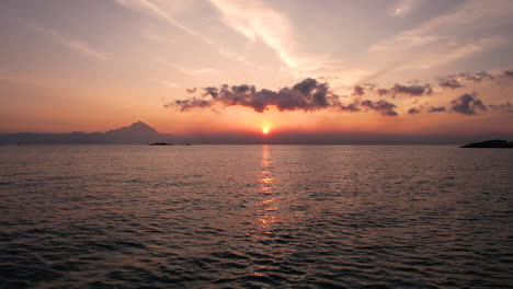 Tiefflug-über-Dem-Meer-Bei-Sonnenaufgang,-Morgensonne-Und-Wolken-über-Dem-Horizont,-Drohnenschuss