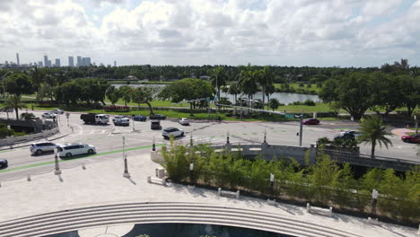 Luftaufnahme-Des-Verkehrs-Vor-Dem-Holocaust-Denkmal-In-Miami,-USA,-Gigantische-Handskulptur-Und-Golfplatz-Im-Hintergrund,-Drohnenaufnahme