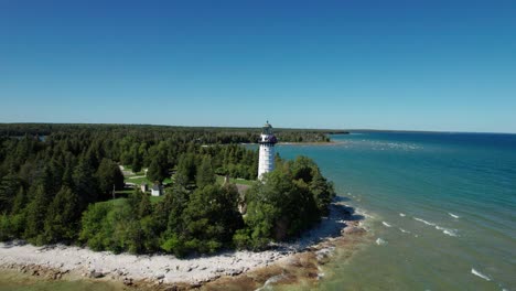 Toma-Aérea-De-Un-Dron-Alejándose-De-Un-Faro-En-Las-Costas-Del-Condado-De-Door,-Wisconsin.