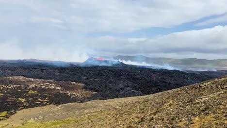 Volcanic-eruption-at-Fagradalsfjall-with-lava-and-smoke,-wide-shot-in-daylight,-Iceland