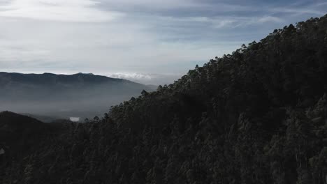 Aerial-drone-view-drone-camera-is-moving-forward-and-big-mountains-are-visible-above-the-cloud