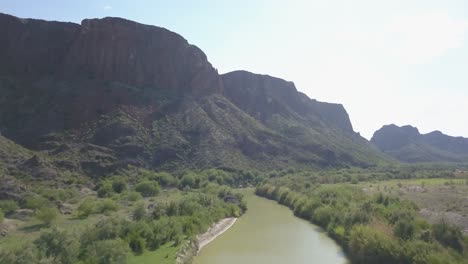 Drone:-Flotando-Sobre-El-Río-Grande-Con-Montañas-épicas-Al-Fondo