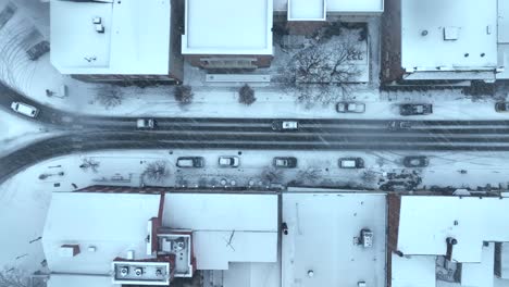 Top-down-aerial-view-of-town-street-during-blizzard