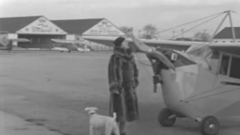 Woman-in-Fur-Coat-Stands-on-Roosevelt-Field-Next-to-Pet-in-New-York-1930s