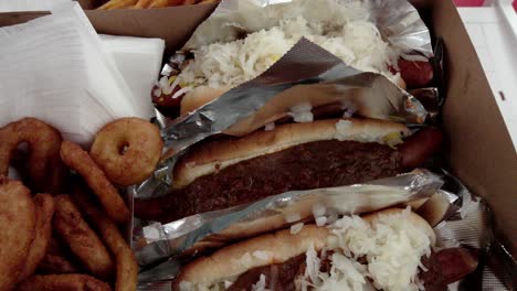 Hot-Dogs,-Pommes-Frites-Und-Zwiebelringe-Von-Pink&#39;s-Hot-Dogs-In-Los-Angeles,-Kalifornien,-Mit-Nach-Unten-Geneigtem-Video