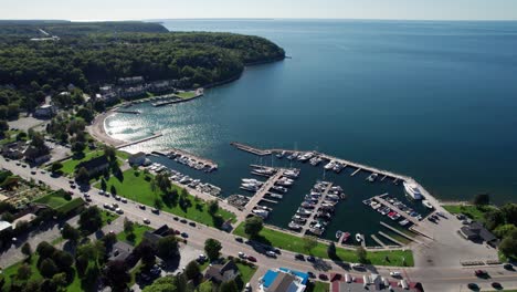 Vista-Aérea-De-Drones-Con-Vistas-Al-Puerto-En-Sister-Bay,-Wisconsin-Con-Reflejo-Del-Sol.