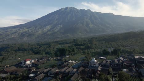 Fly-over-on-village-with-mountain-background