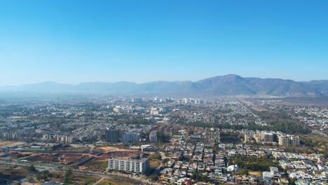 Amplia-Vista-Aérea-De-Las-Zonas-Residenciales-Y-Comerciales-De-Islamabad-Con-Las-Colinas-De-Margalla-Como-Telón-De-Fondo.