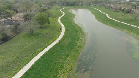 A-top-down-aerial-view-of-an-adult-male-cycling-around-Exploration-Green-in-Clear-Lake,-Houston,-Texas