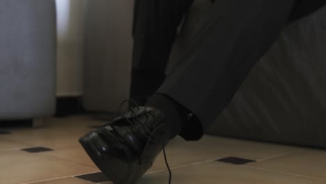 Groom-putting-on-his-shoes,-preparing-for-the-wedding-ceremony