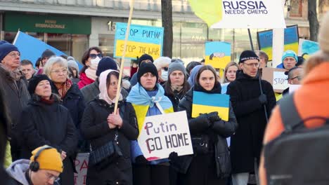 Protesters-with-flags-and-signs-against-Russian-war-in-Ukraine,-slomo