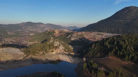 Vista-De-Drones-De-La-Presa-En-Medio-Del-Terreno-Rodeado-De-Altas-Montañas