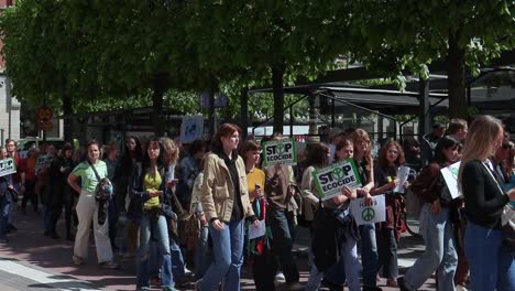 Young-protesters-march-with-signs-at-environmental-rally,-slow-motion