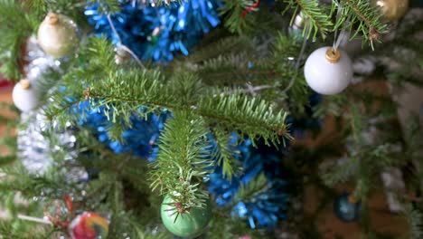 Bird´s-eye-view-of-a-Christmas-pine-tree-branches-adorned-with-numerous-ornaments-during-the-winter-season